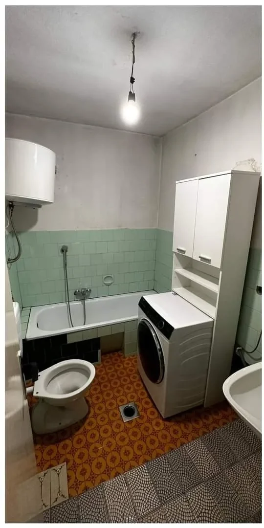 Voor de renovatie: grijze badkamer